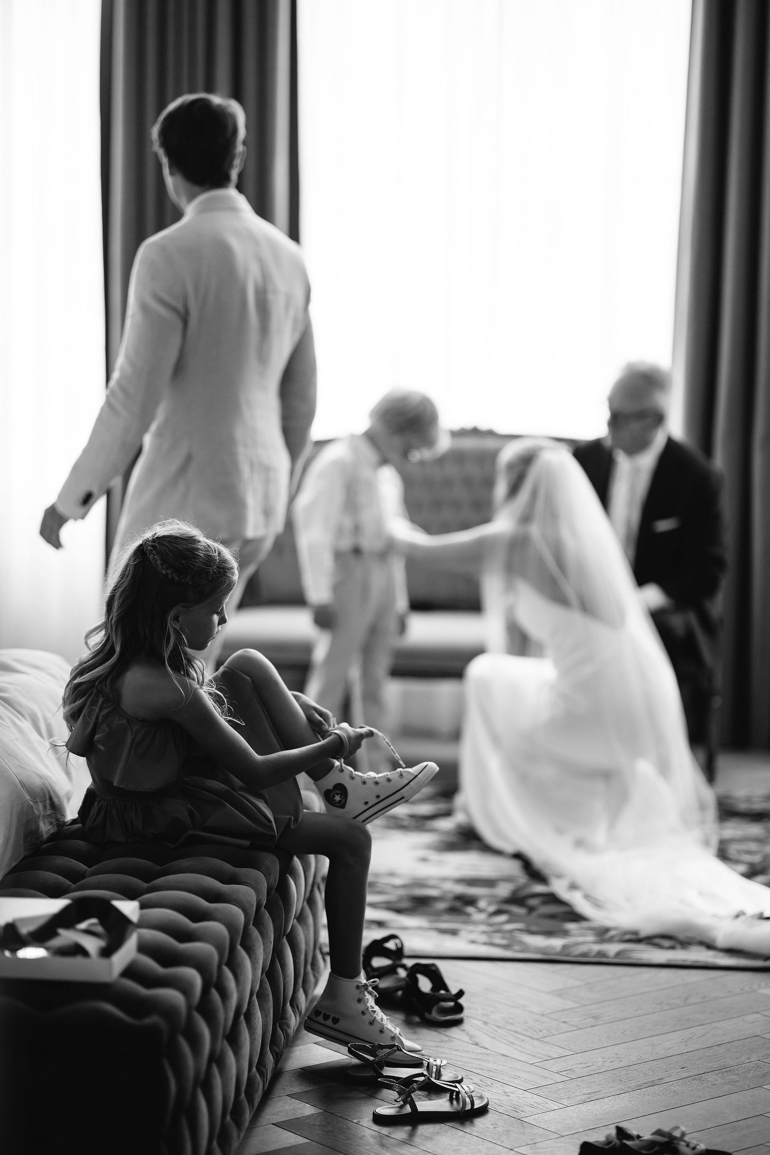 Black and white candid photos of wedding preparations in a hotel room.