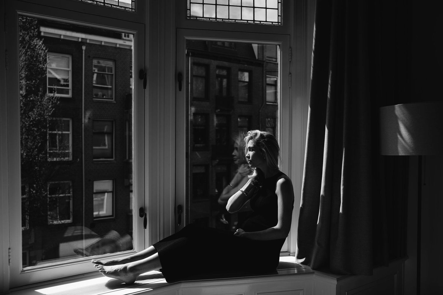 Moody black and white interior shots showing window light and architectural details.
