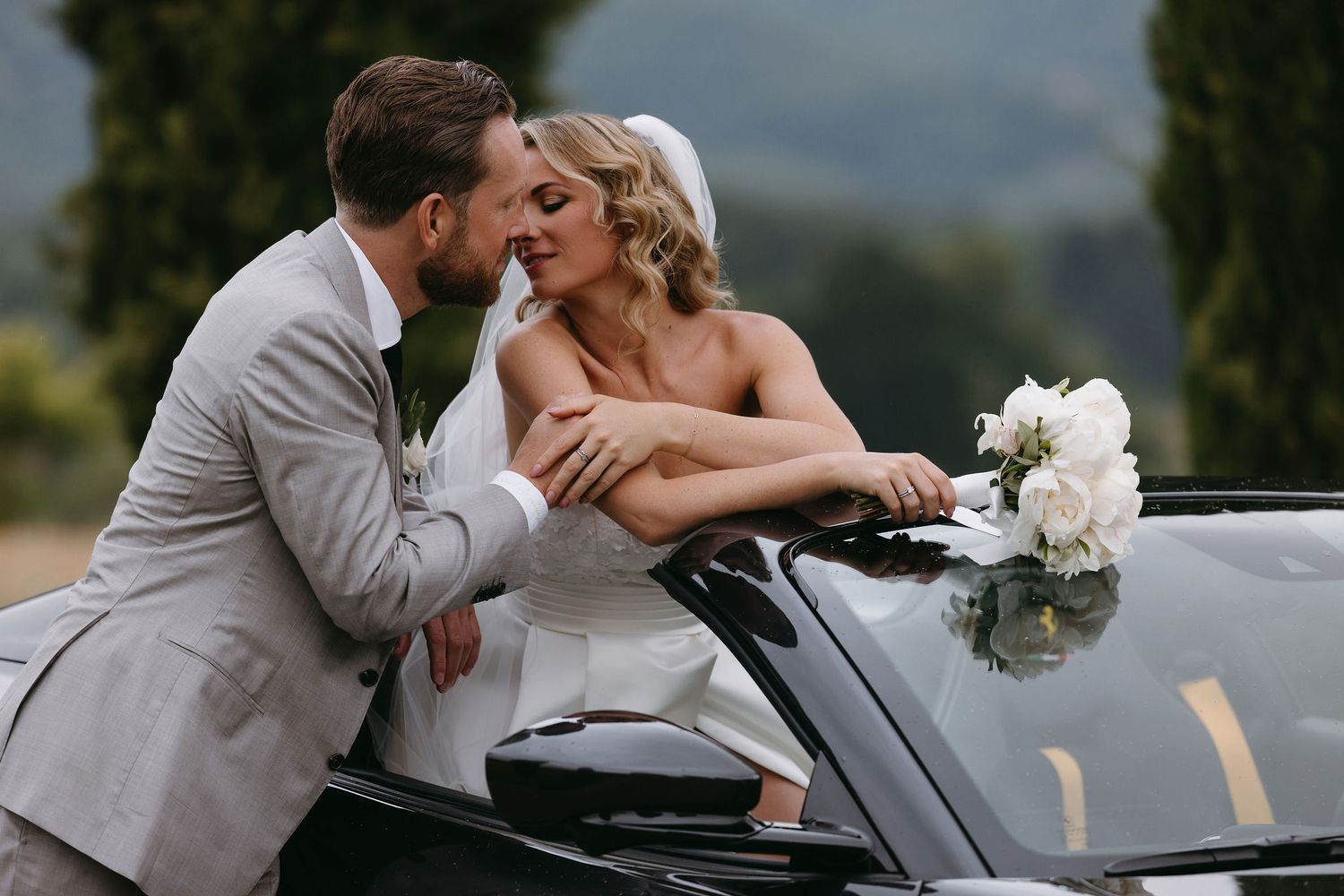 Wedding couple sharing a romantic moment in a vintage car.