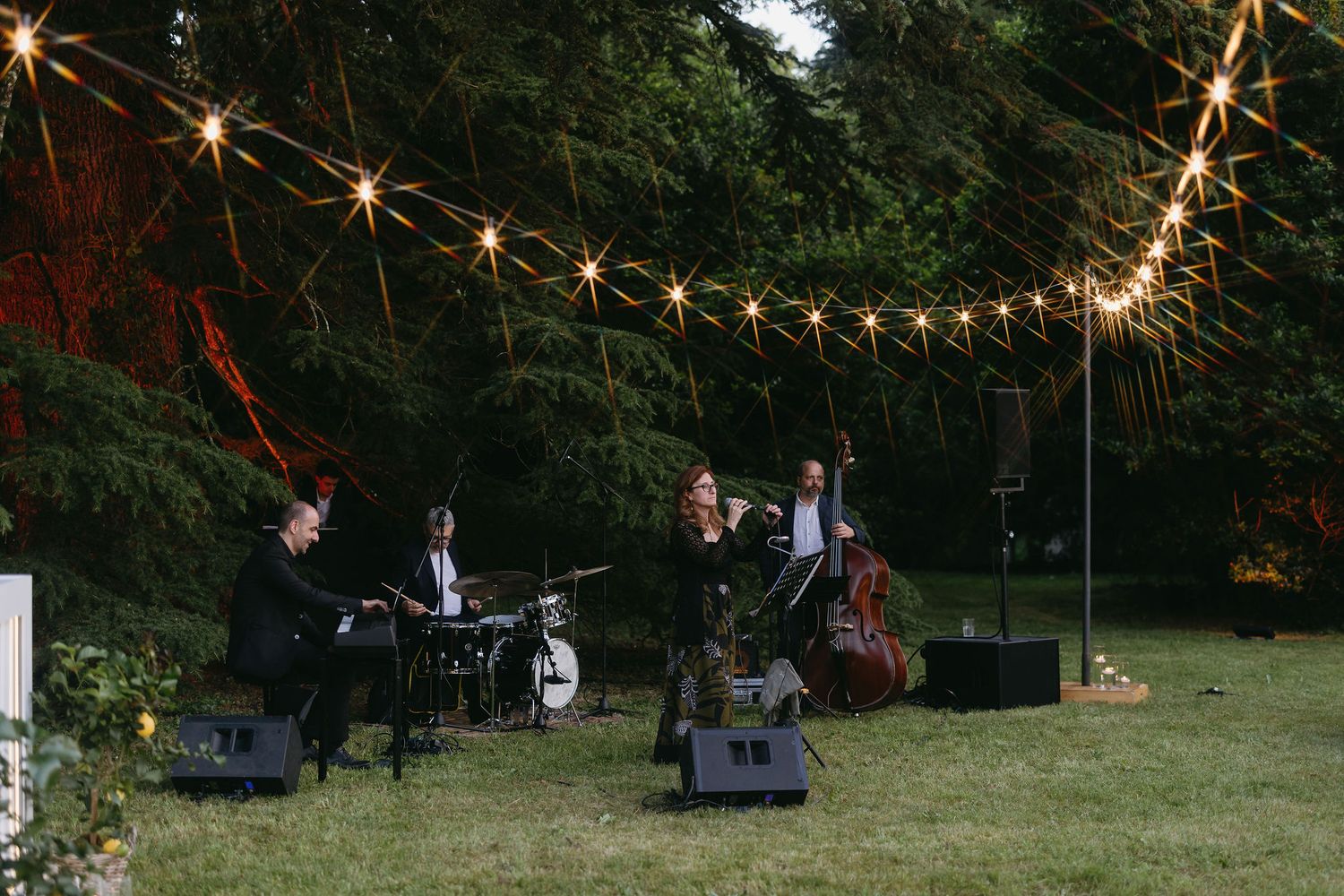 Garden party setting with string lights hanging above creating a romantic evening ambiance.