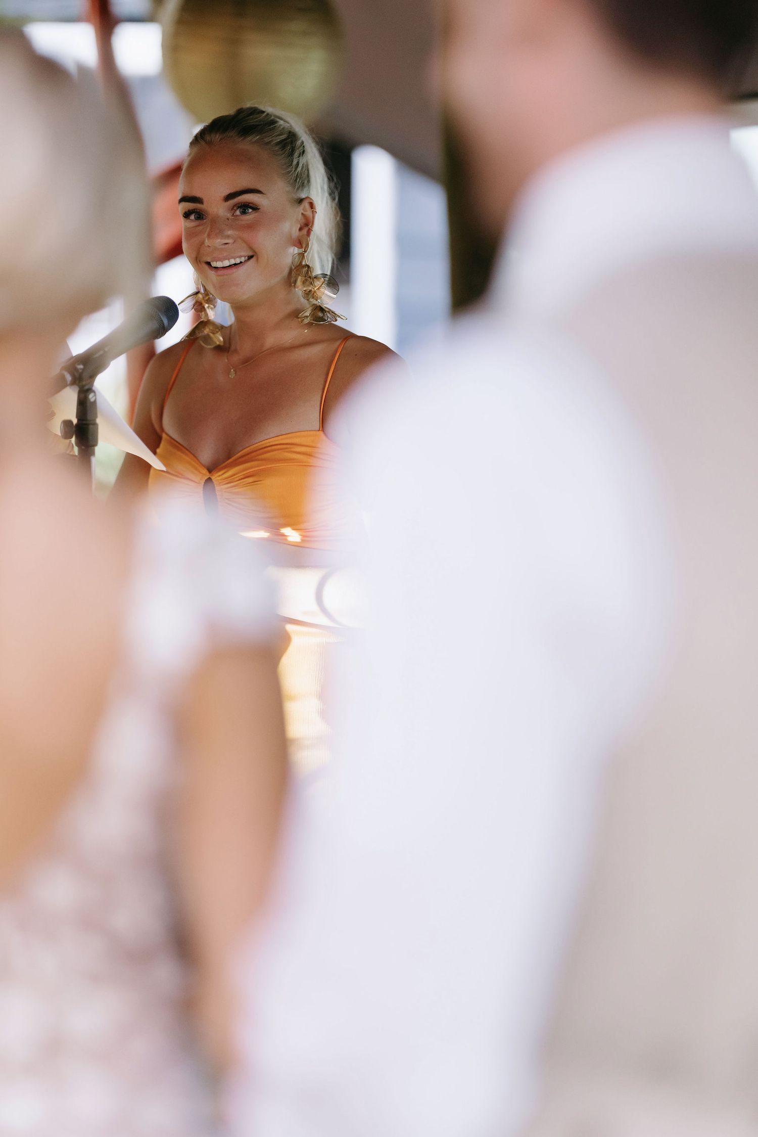 Wedding party members in beige and white attire celebrating at outdoor event.