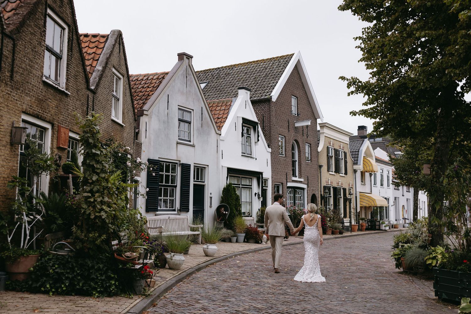 Charming cobblestone street lined with traditional Dutch houses and white shuttered windows.
