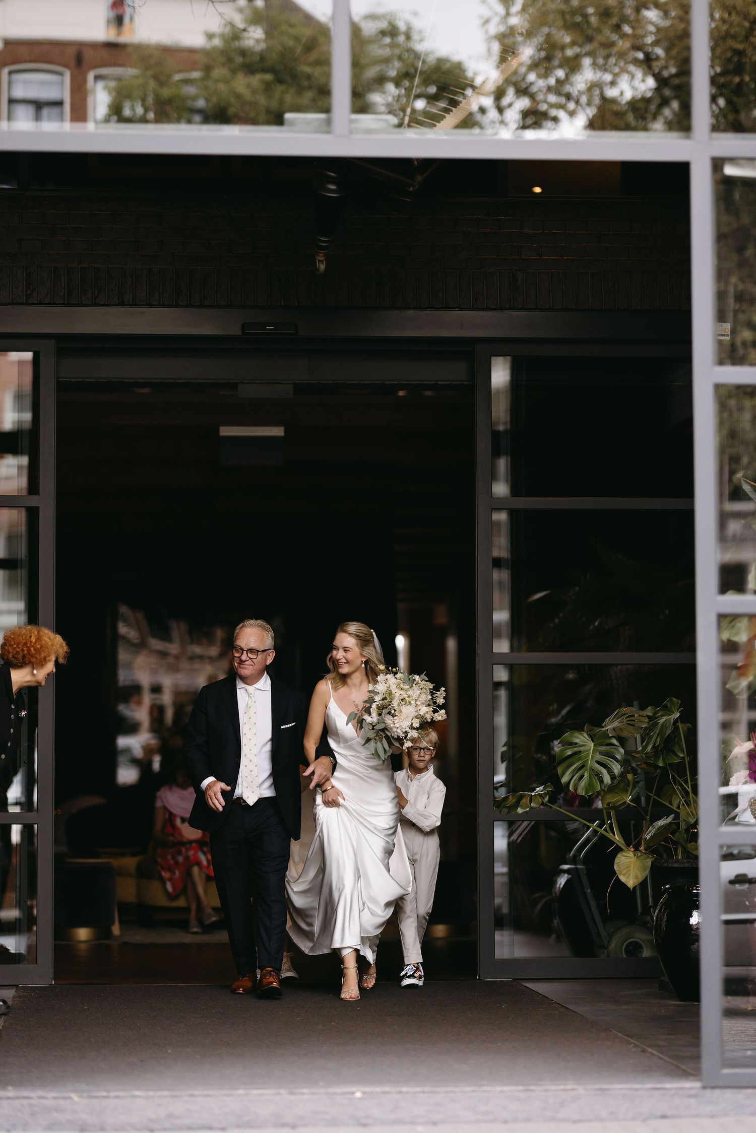 Wedding party running through an industrial-style parking garage at night.