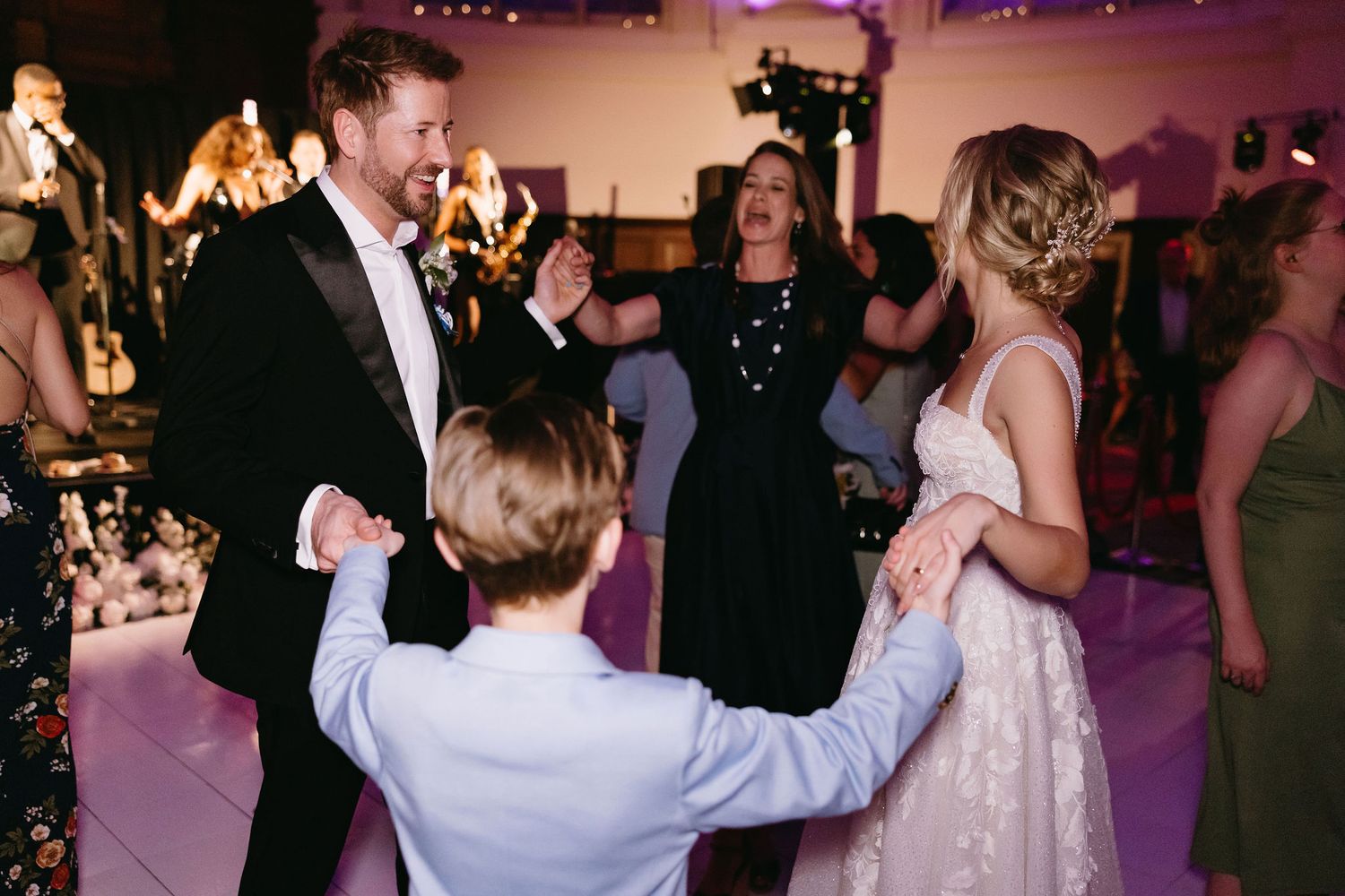 Wedding celebration on a dance floor with purple mood lighting.