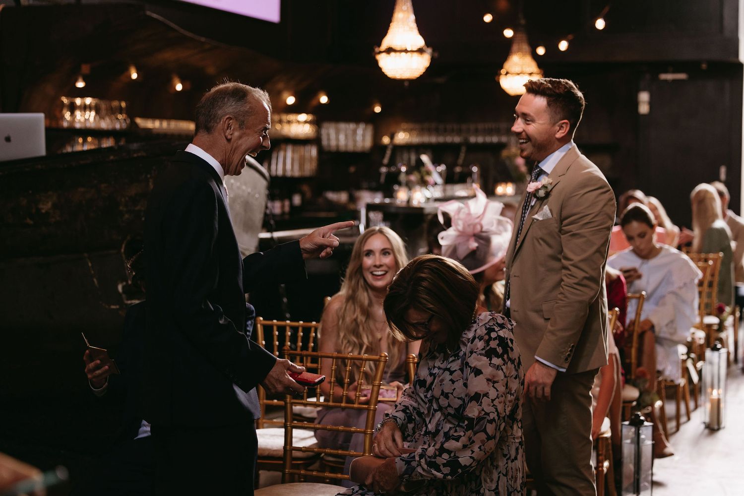 Wedding reception venue with ambient lighting and guests mingling in the background.