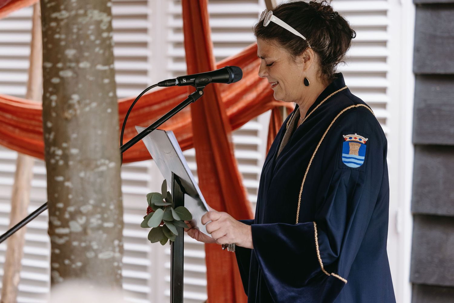Person in navy jacket enjoying festivities at outdoor wedding reception.