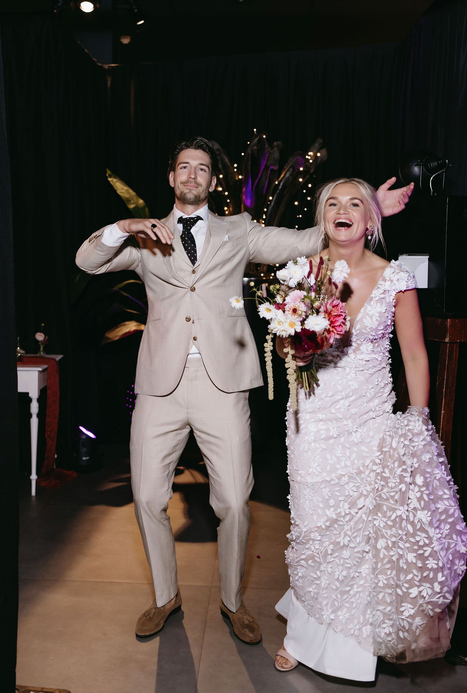 A joyful wedding celebration moment with a couple in formal attire celebrating during their reception.