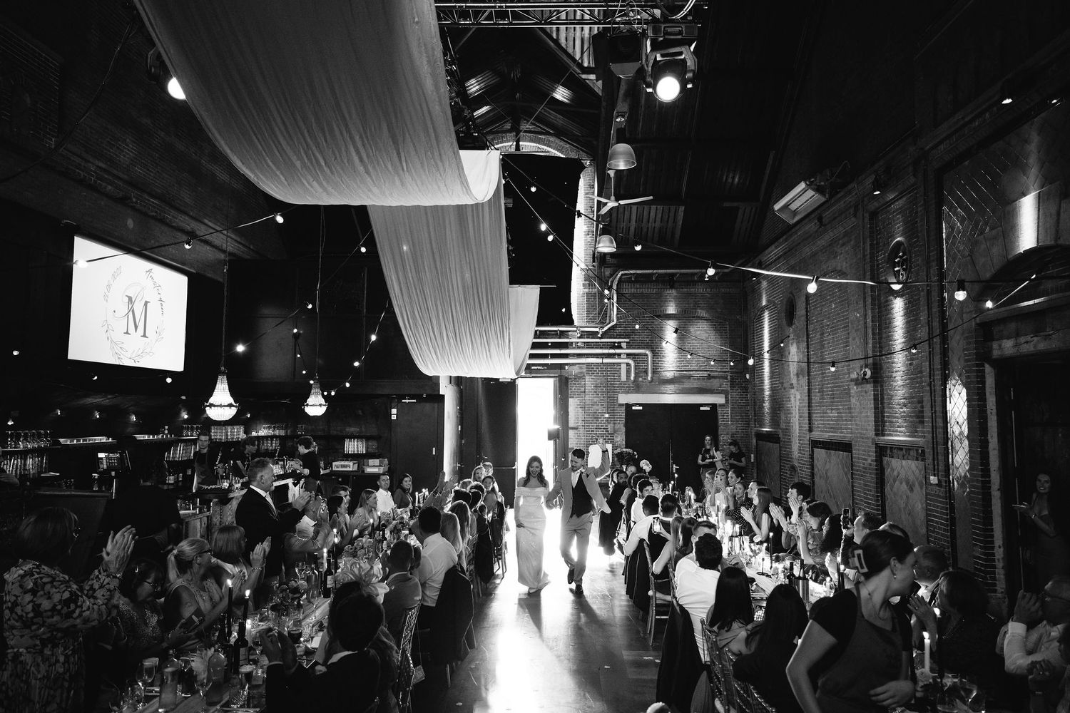 Wide panoramic views of a wedding reception venue with dramatic lighting and seated guests.