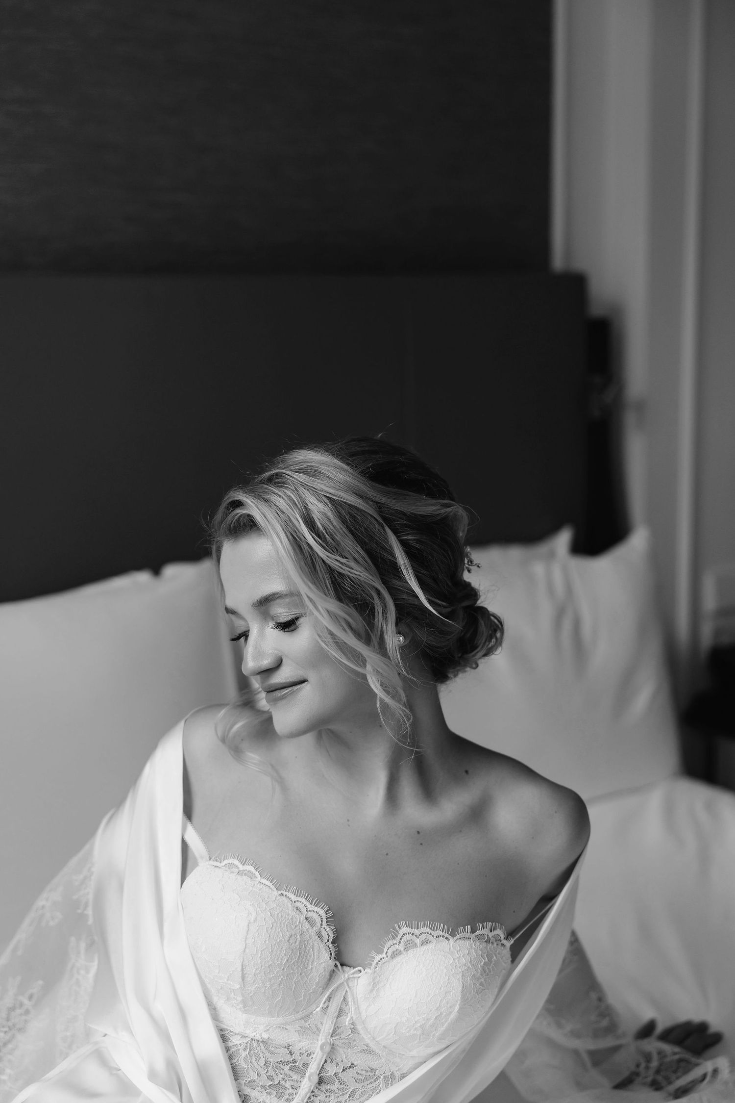 An intimate black and white bridal portrait showing preparation moments before the ceremony.