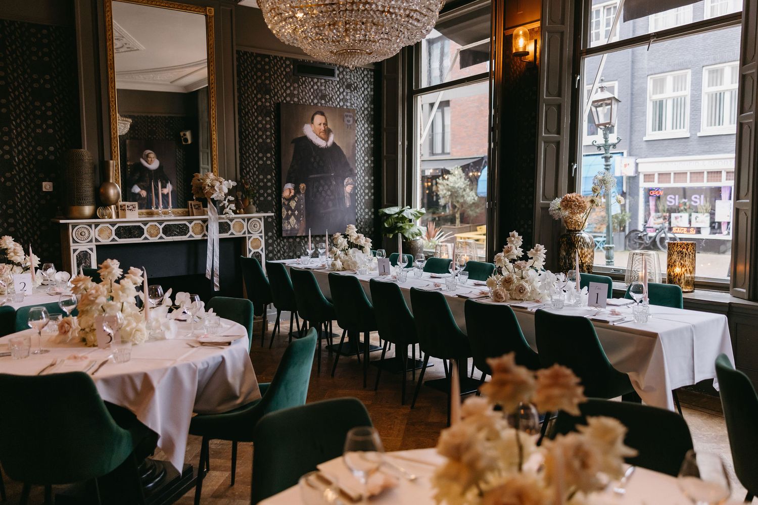 An elegant restaurant dining room with crystal chandeliers and formal place settings.