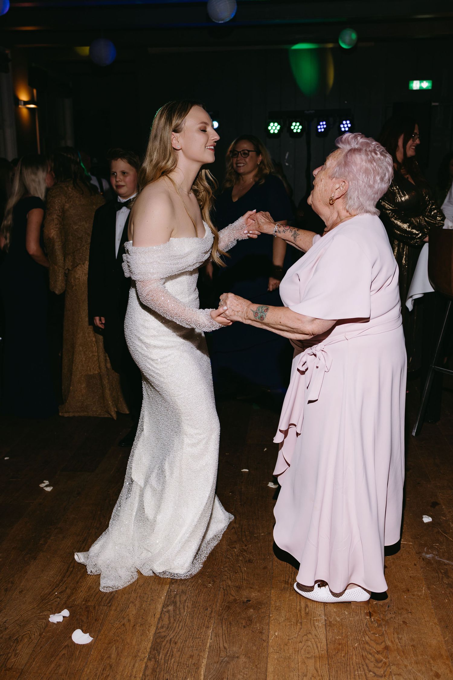 Dancing together on a wooden floor during an evening celebration.
