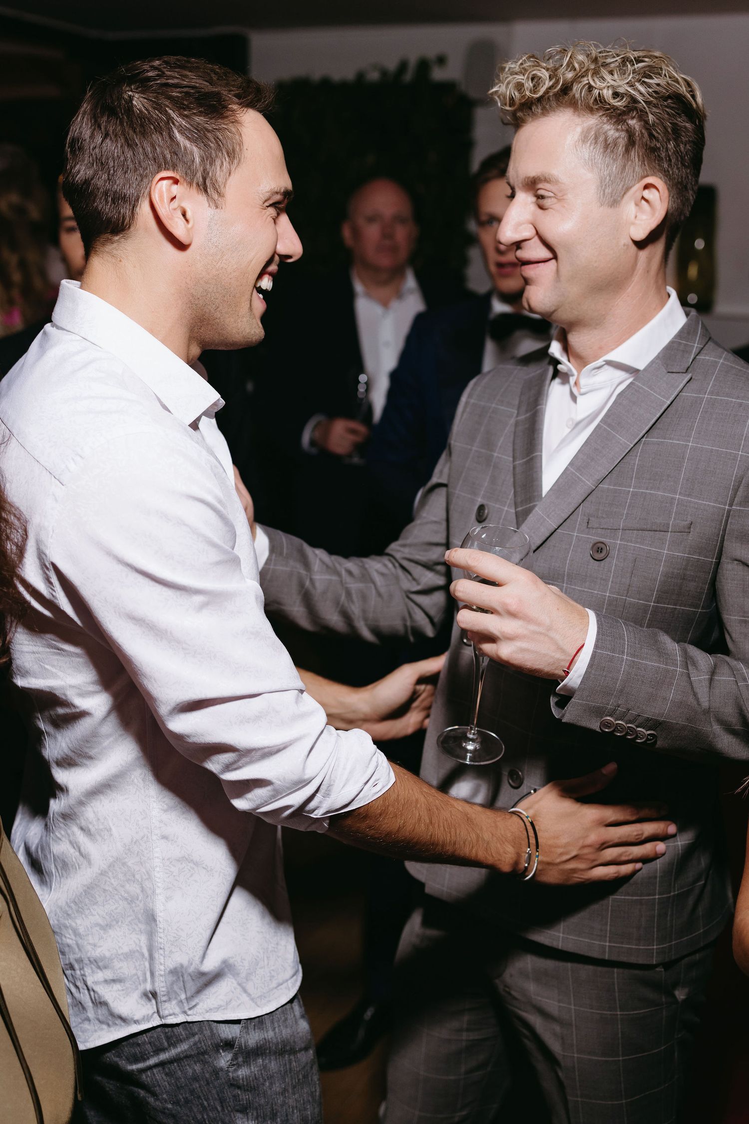 Two guests share a laugh and conversation during a wedding reception.
