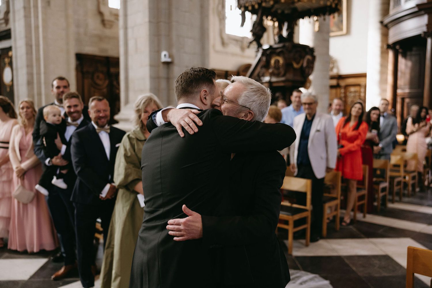 Wedding guests gather in a stone-walled venue during the ceremony celebrations.