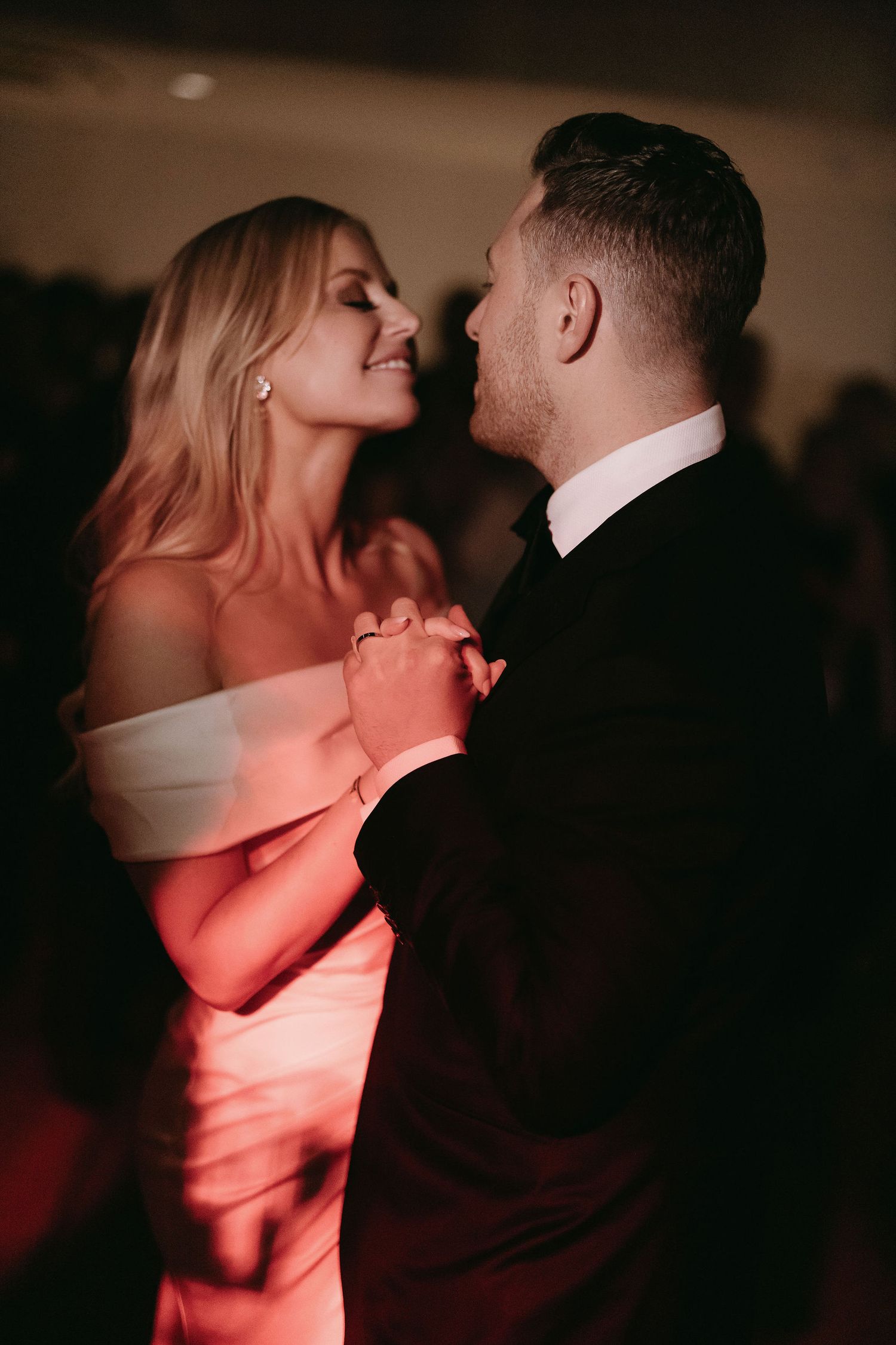 Romantic dance scene in warm lighting at an evening wedding reception.