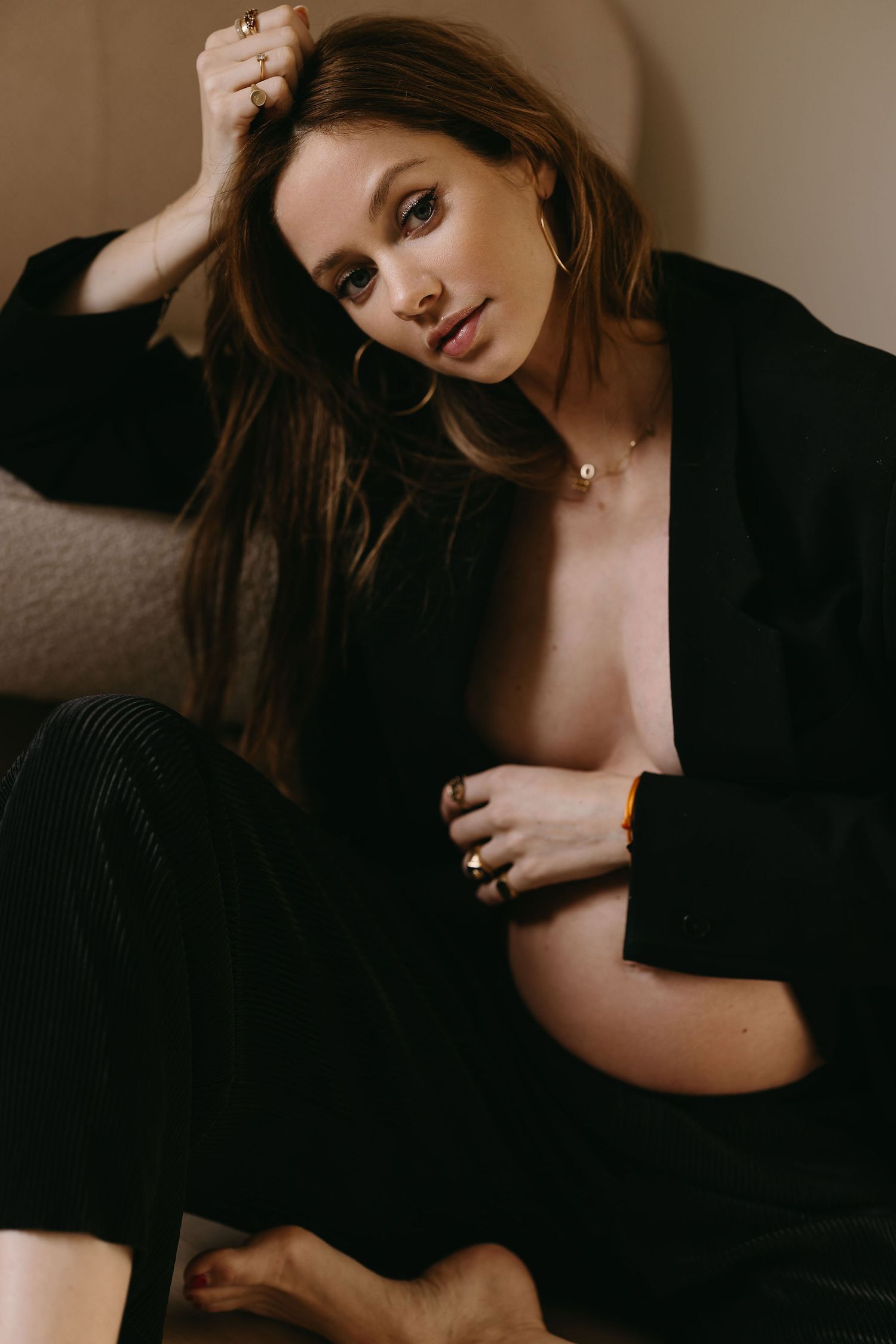 Artistic boudoir portrait in moody lighting with black clothing and natural styling.