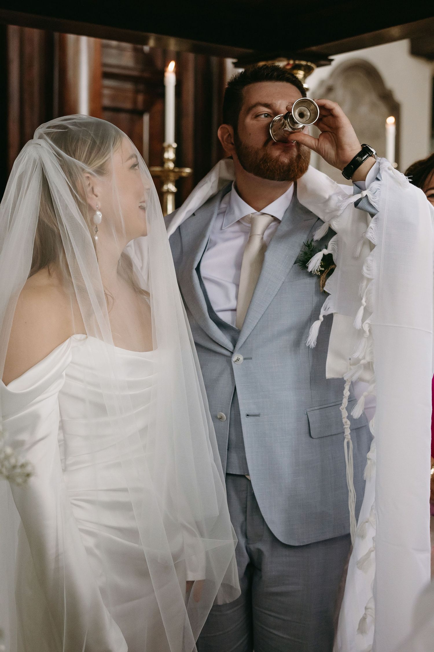 Wedding couple in white dress and grey suit sharing intimate moment.