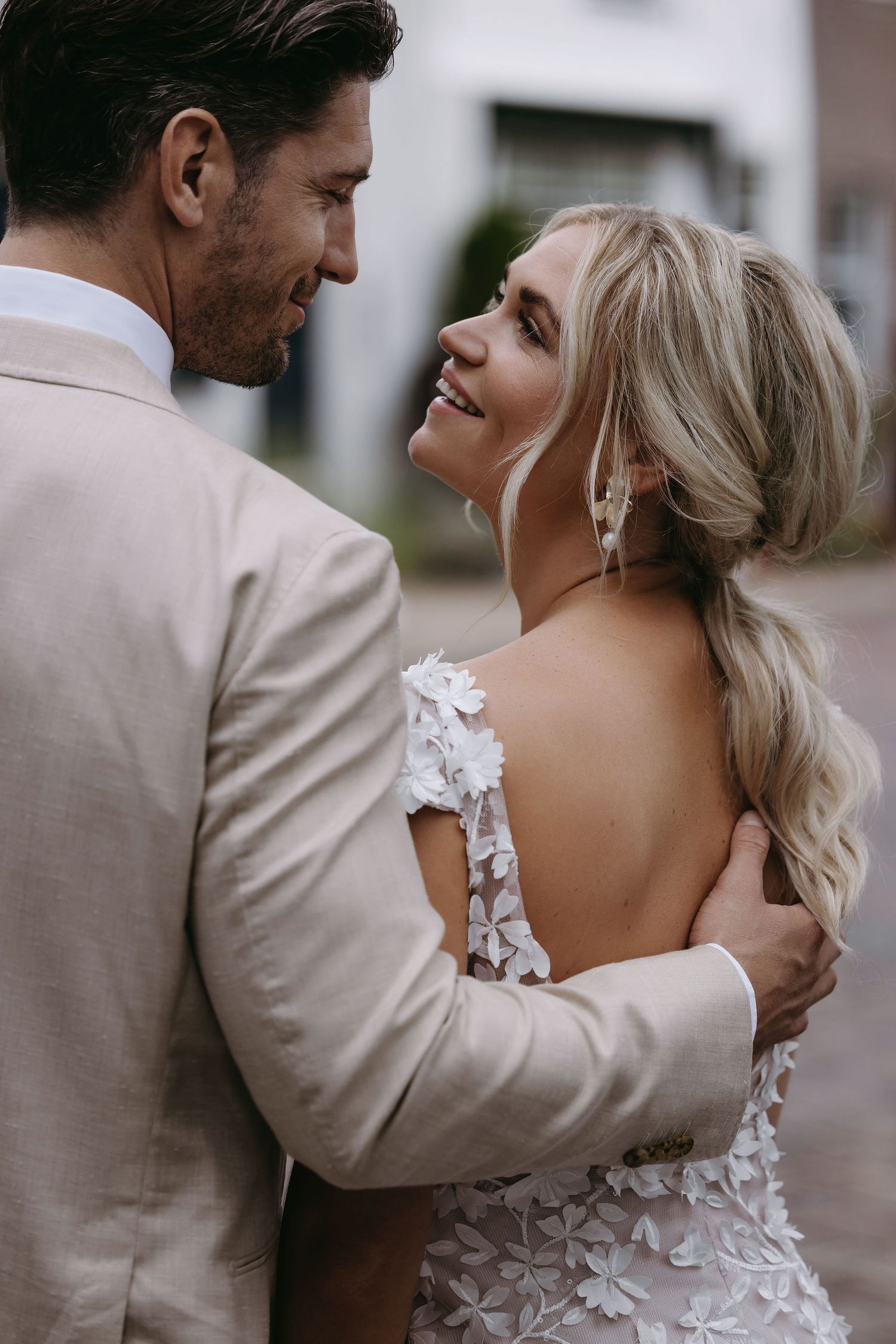 Close up shot of couple in formal attire embracing during romantic moment.