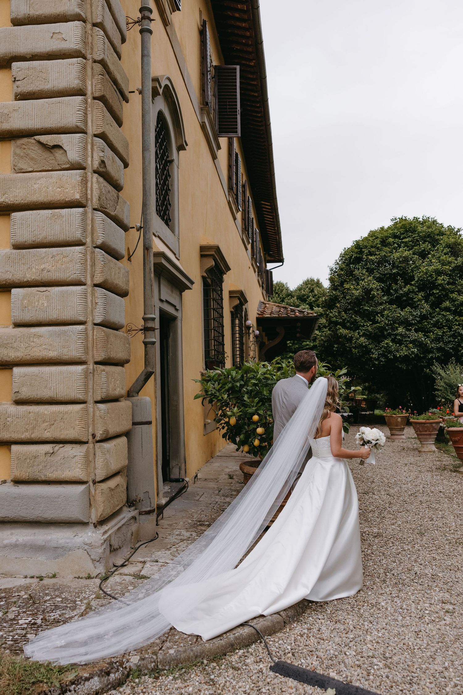 Beautiful wedding setting outside an Italian villa with elegant architecture and gravel pathway.