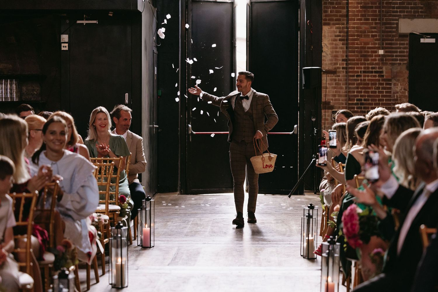 Indoor wedding ceremony venue with rows of chairs and confetti in the air.