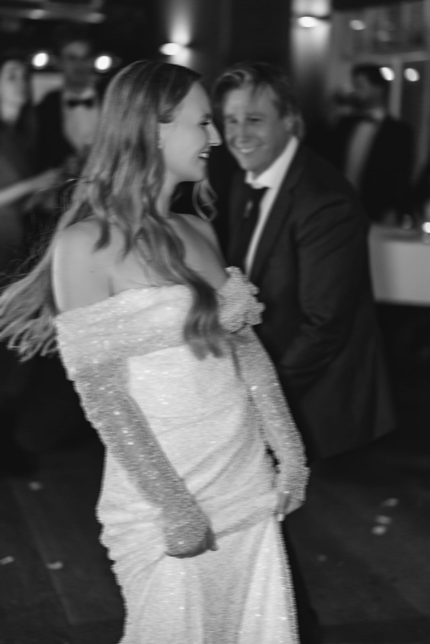 Dancing sequence at a wedding reception showing movement in a sparkling white dress.