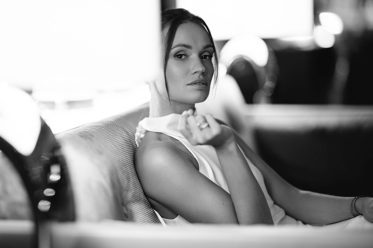 A black and white portrait photograph shows a reclining pose on a couch in a contemplative mood.