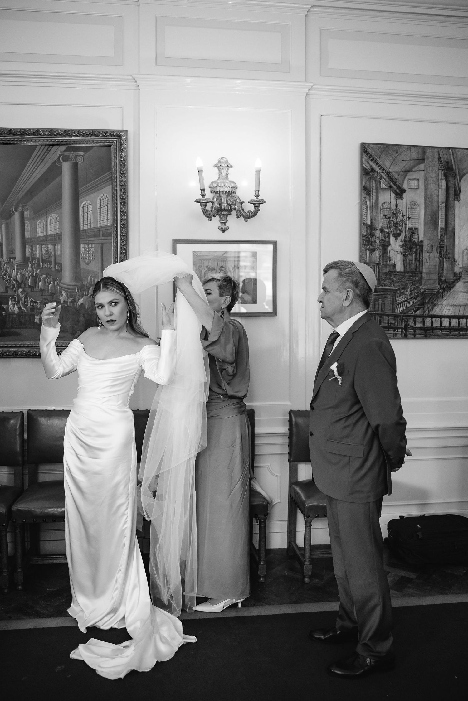 Vintage black and white photos showing group in formal attire against white paneled walls.