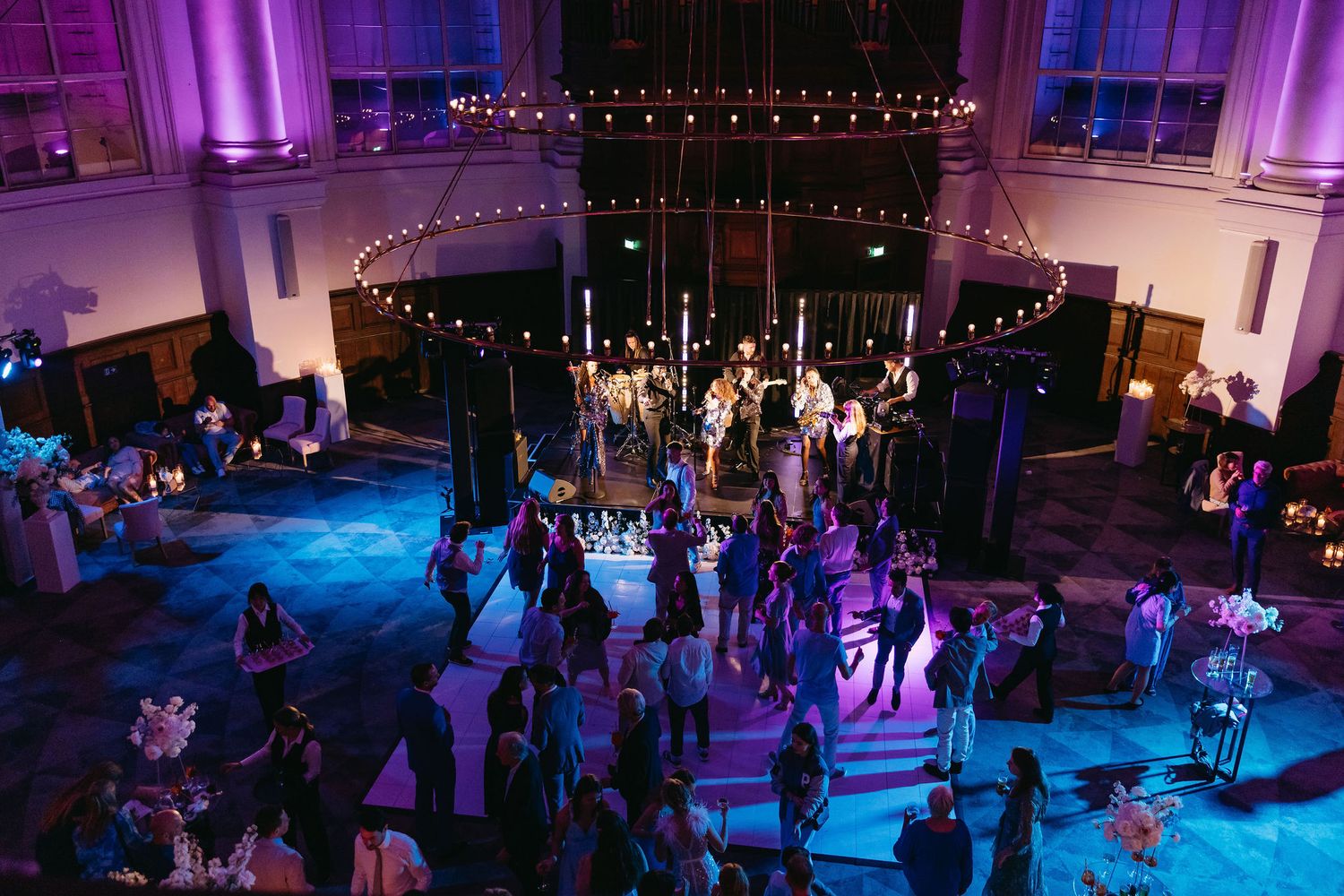Nighttime wedding reception with purple uplighting and string lights creating a magical atmosphere.