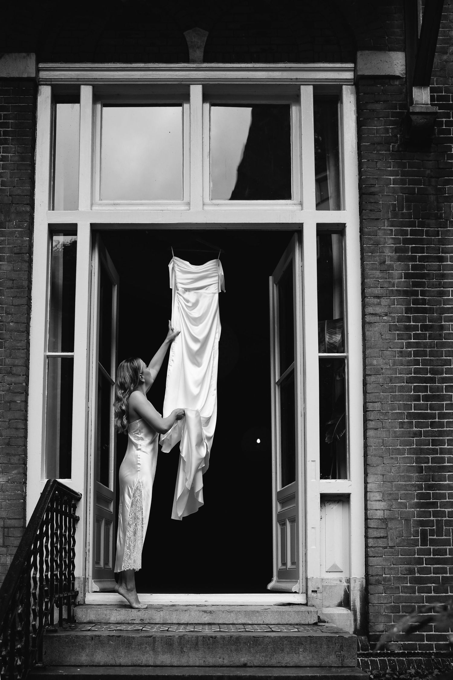 Black and white photo series showing draped fabric in building windows.