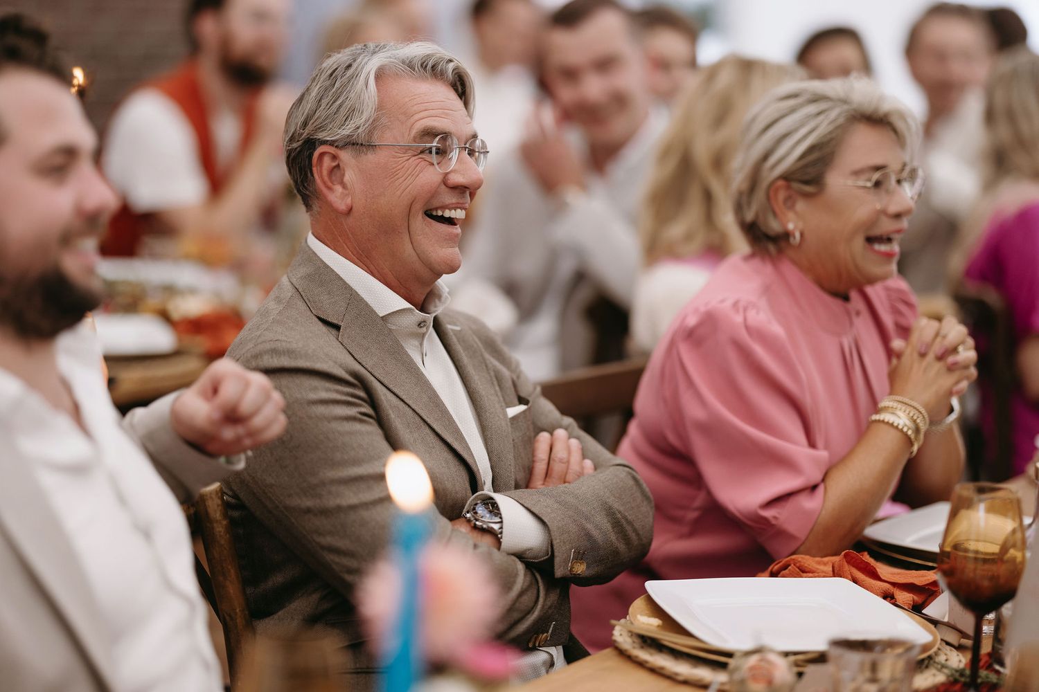 Wedding guests enjoying a meal at reception tables with festive decorations.