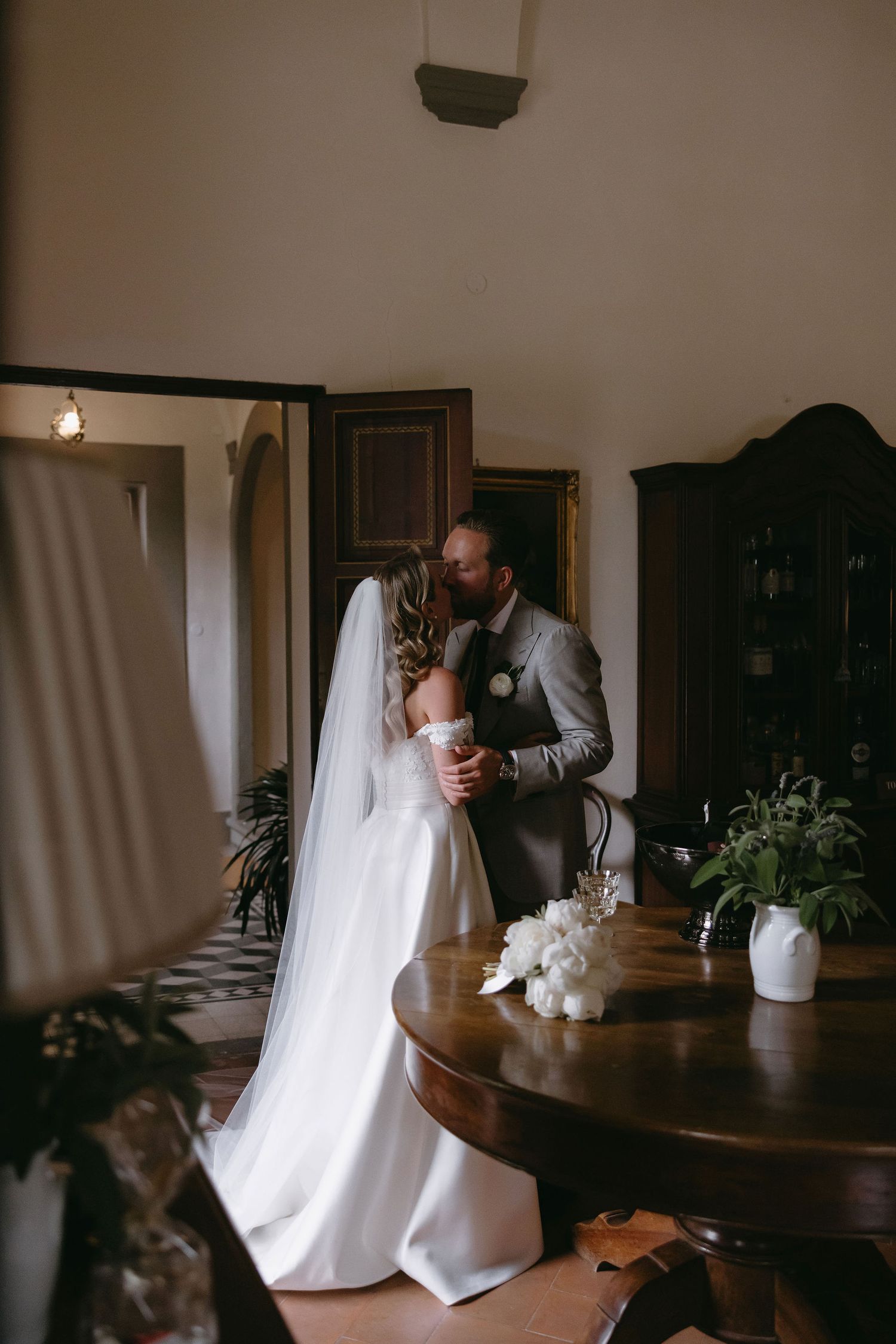 Intimate indoor wedding moment in a rustic room with natural light.
