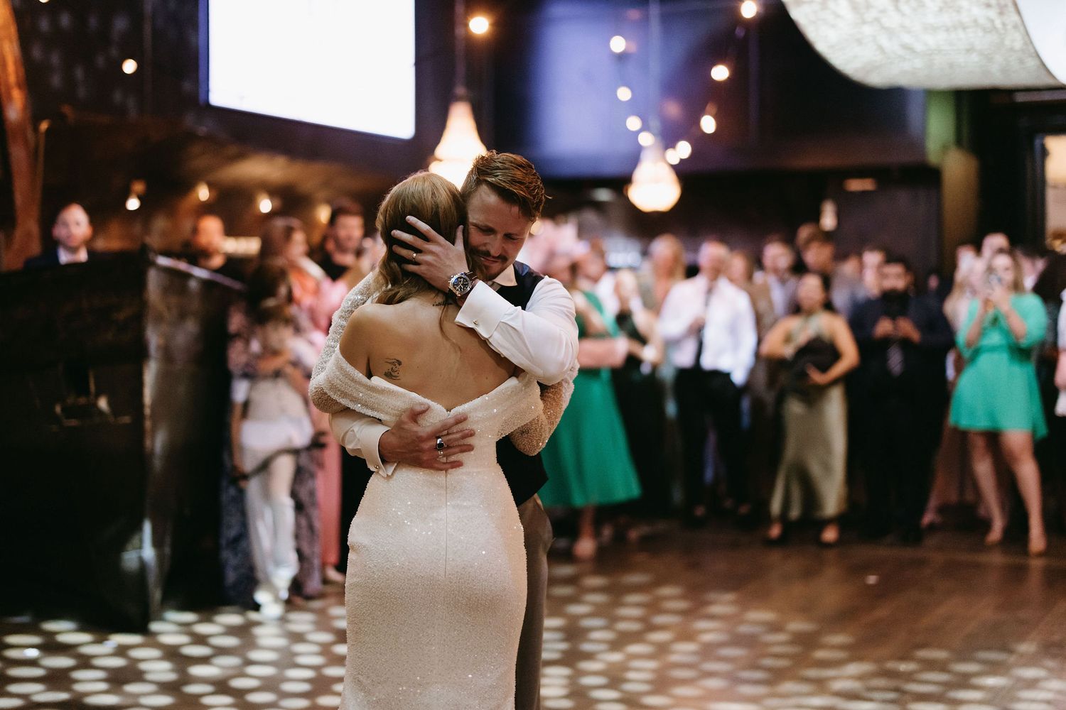 Wedding reception venue with dancing guests and ambient lighting.