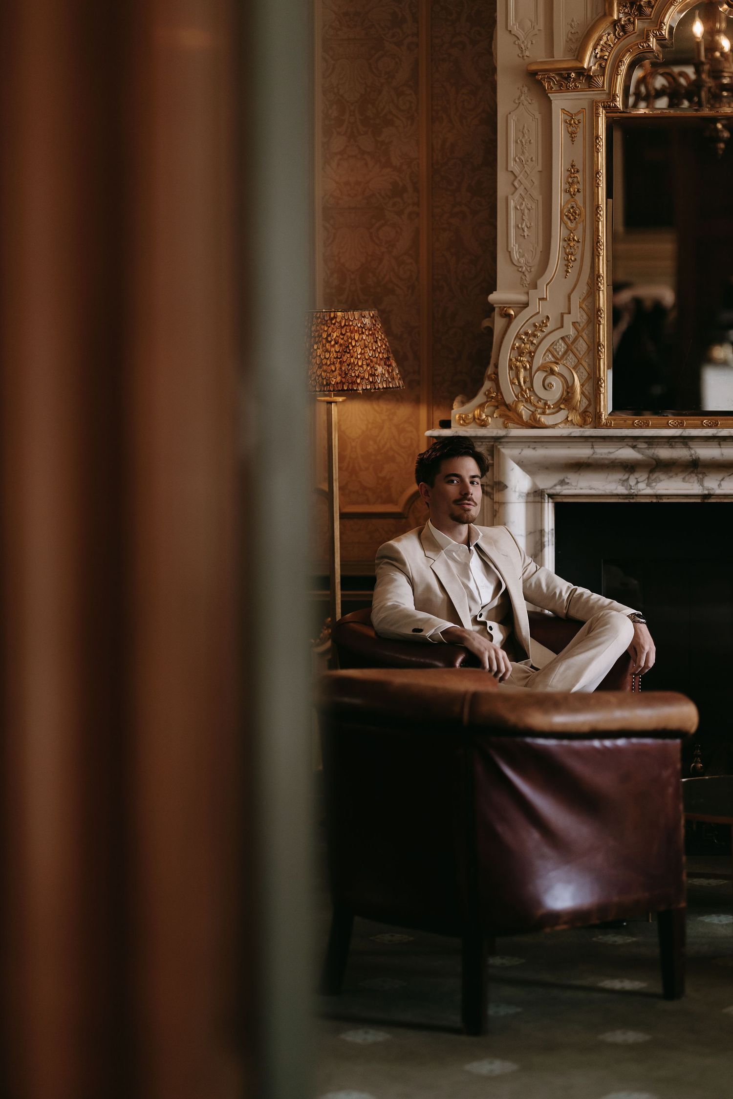 Moody atmospheric portraits in an elegant vintage room with ornate decor and leather seating.