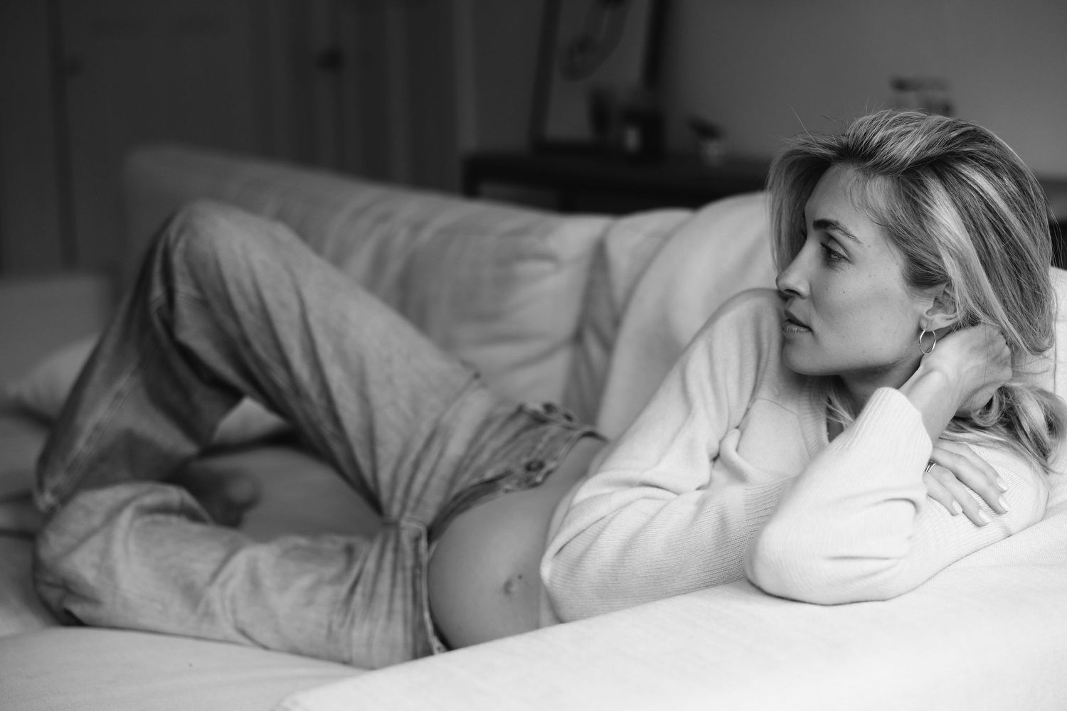 Relaxed black and white portrait on bed.