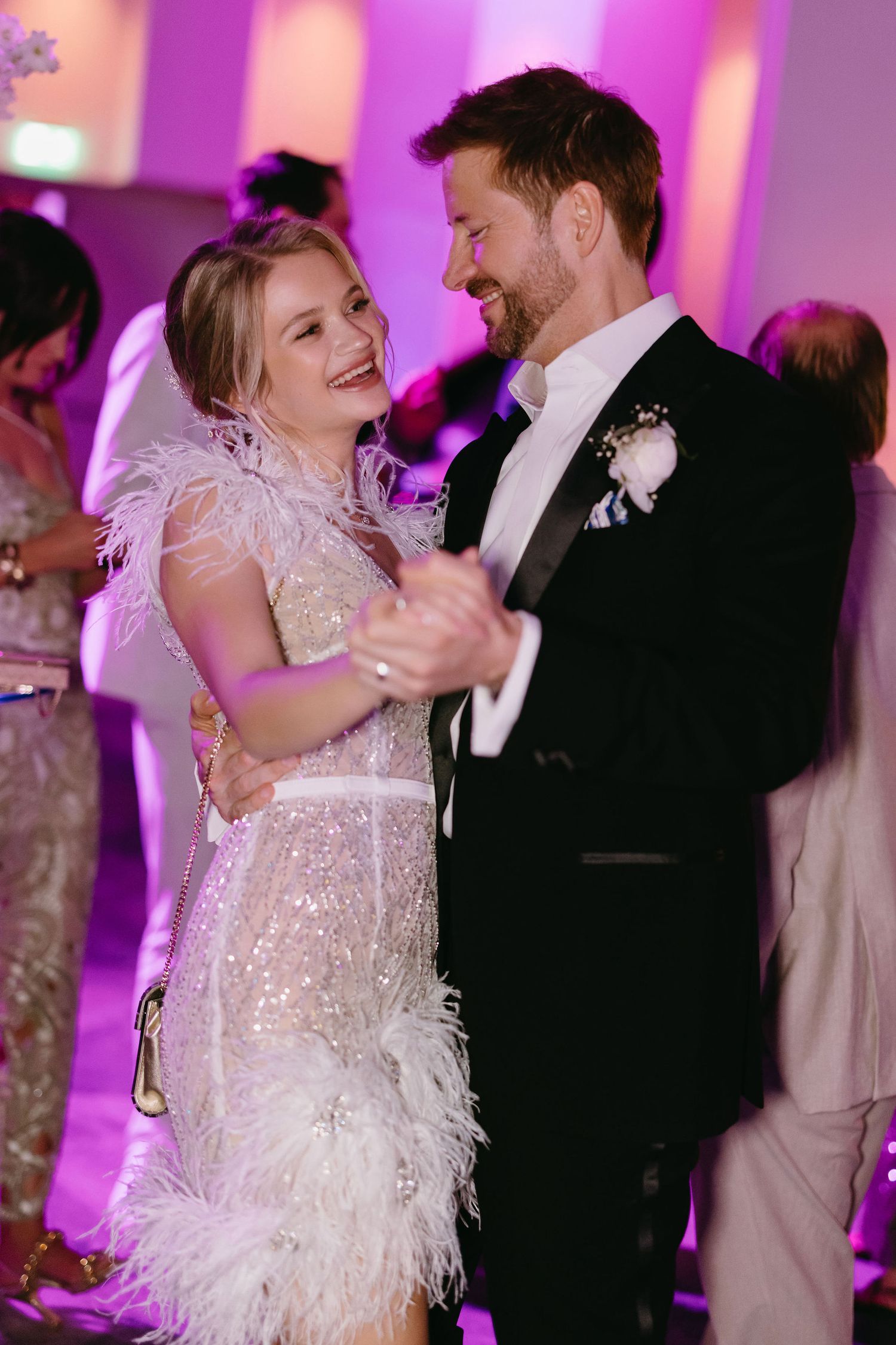Couple dancing under purple lighting at their wedding reception.