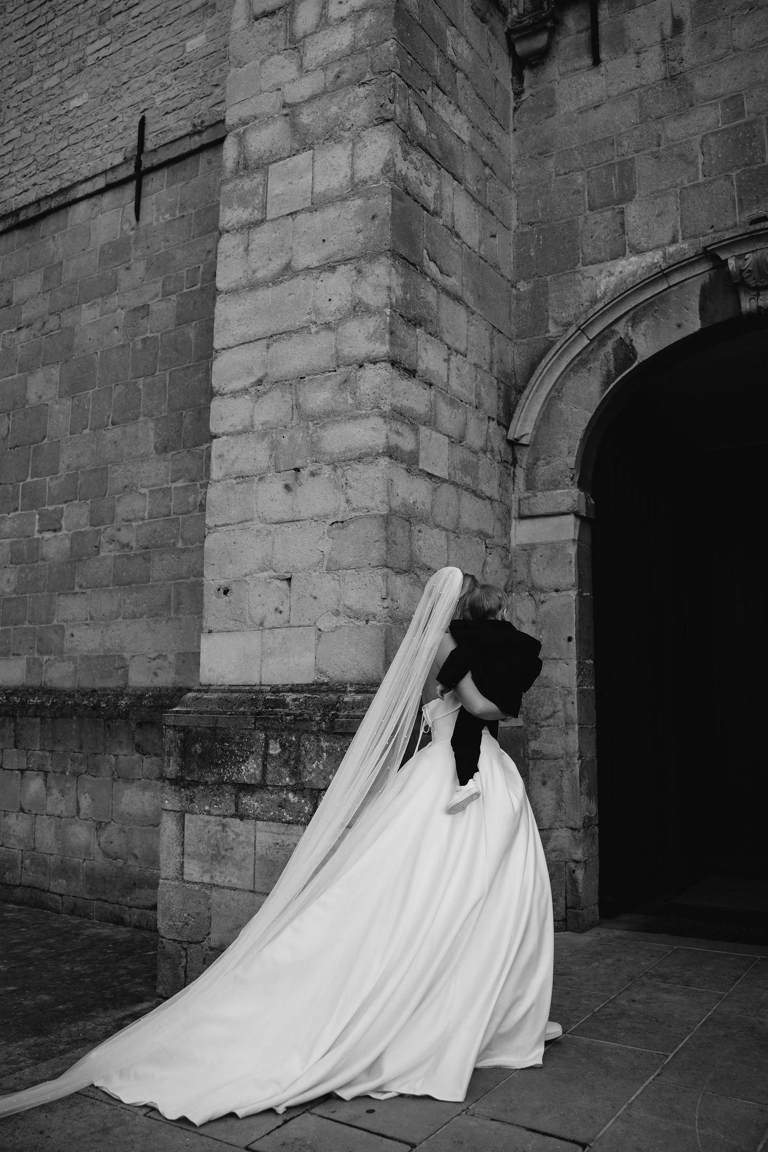 Four sequential black and white images show a ghostly white figure collapsing against a stone wall of a dark corridor.