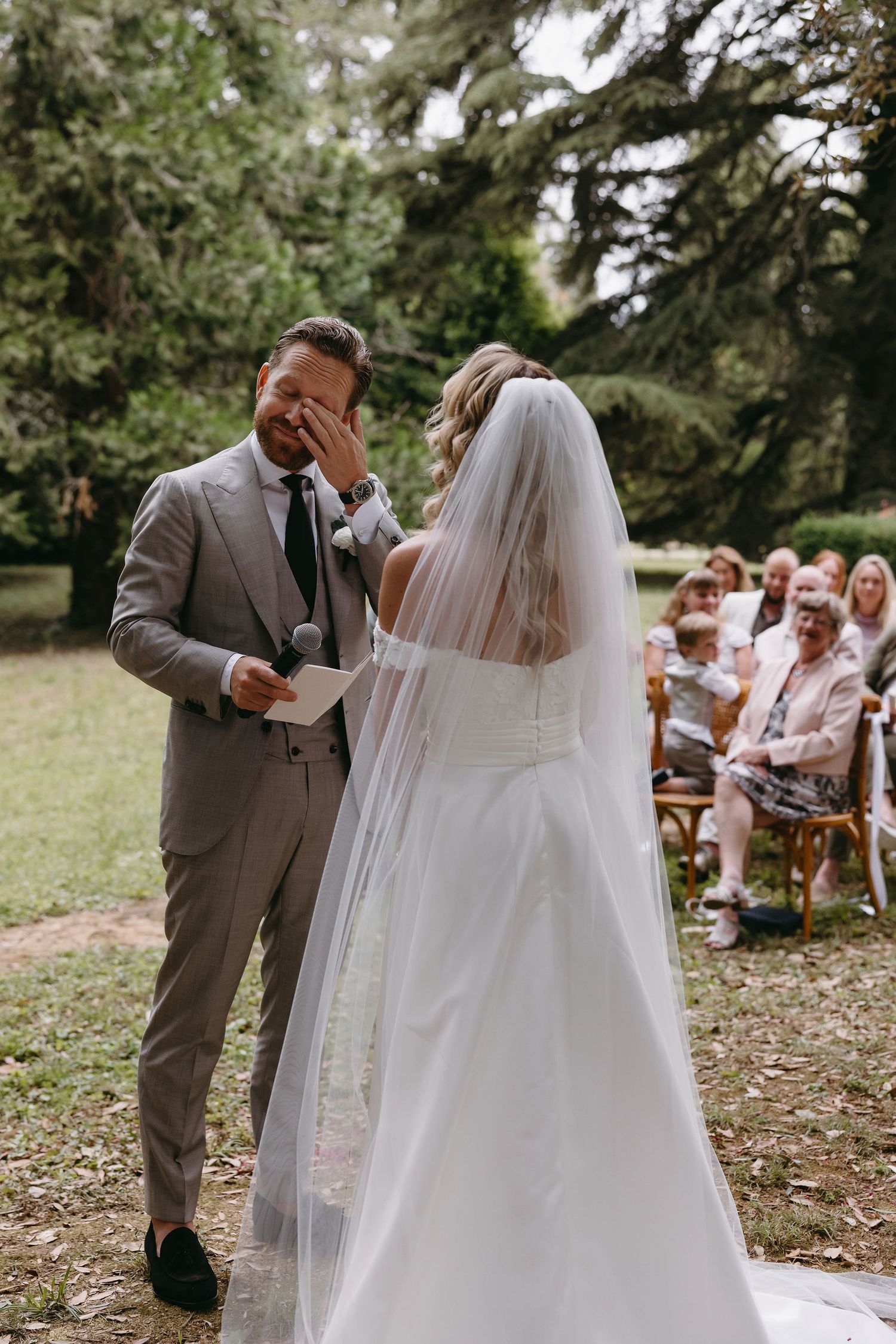 Emotional outdoor wedding ceremony moment in a natural forest setting.