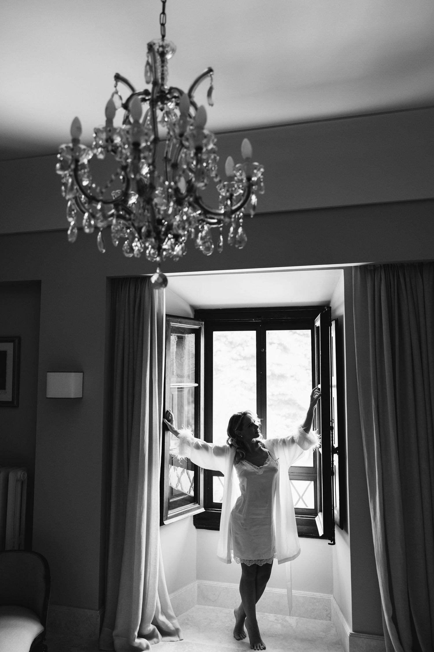 Silhouette by a window with a crystal chandelier in black and white.