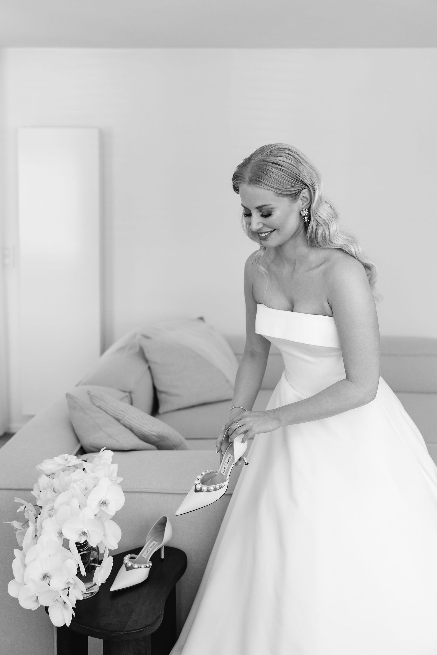 Elegant black and white portrait of a bride preparing with her white orchid bouquet.