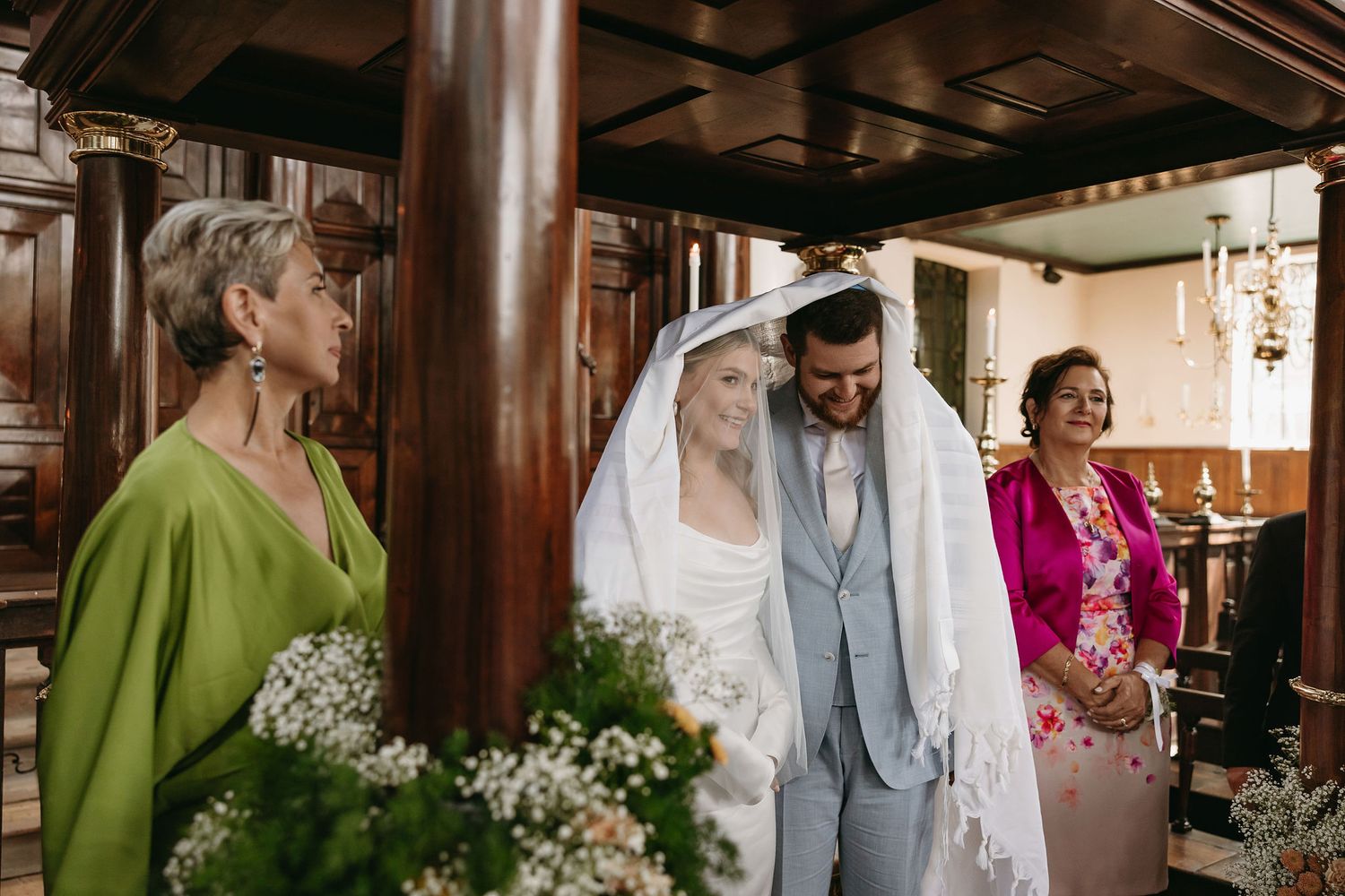 Wedding ceremony in a rustic venue with attendants in colorful attire.