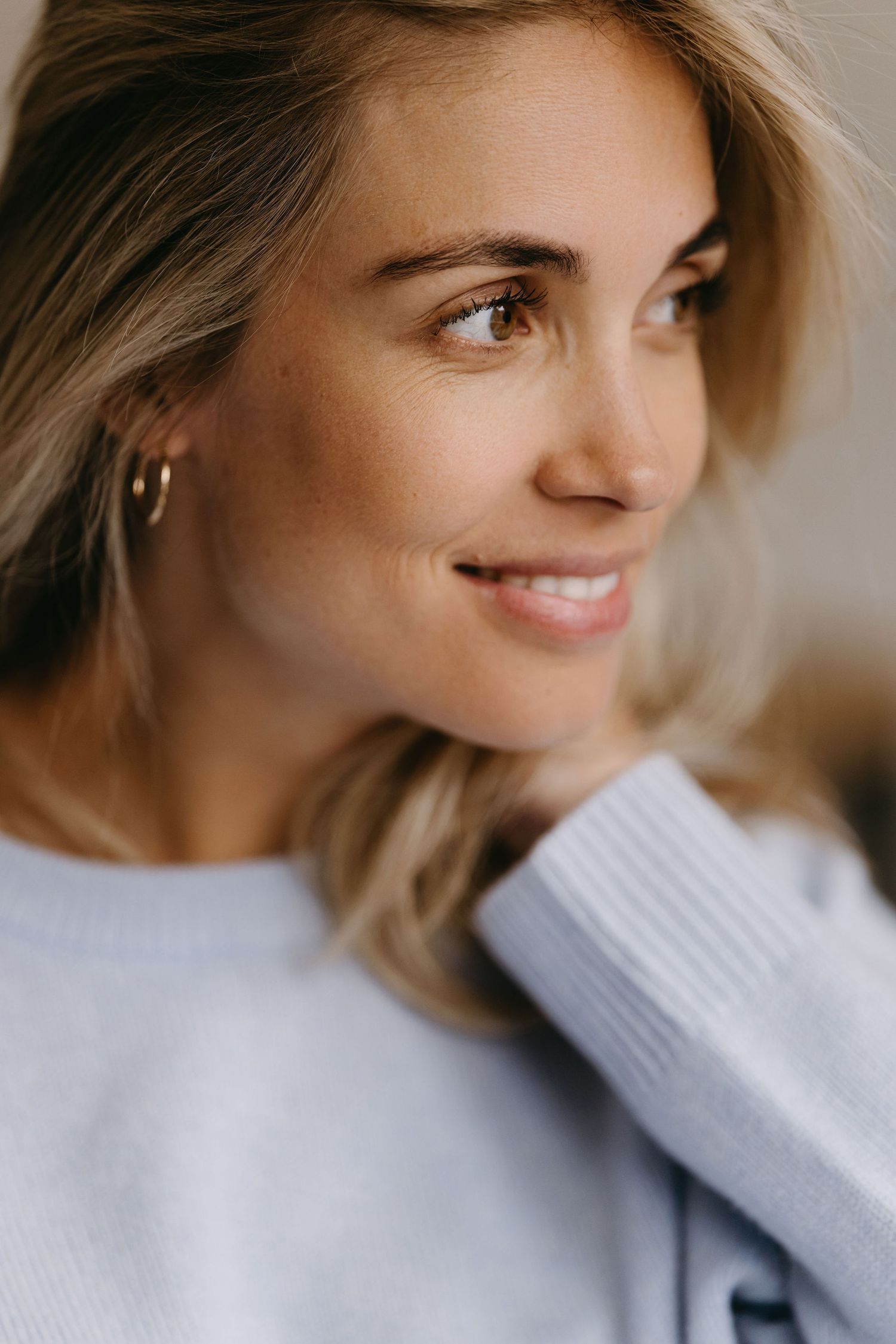 Candid side profile shot wearing soft white sweater.