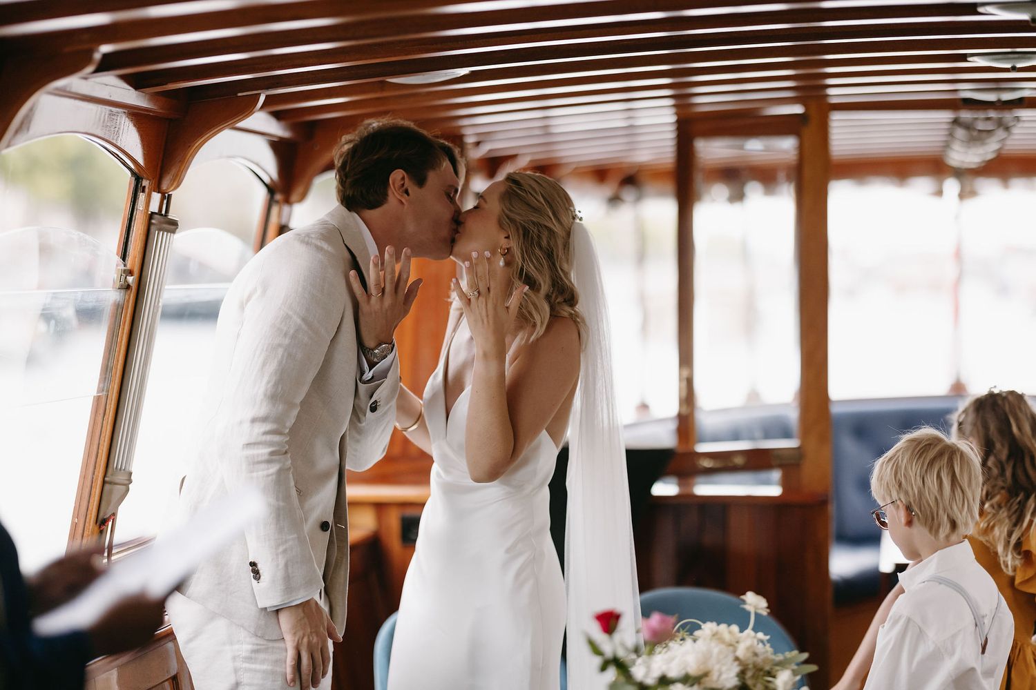Romantic moment aboard a wooden boat with vintage interior details.