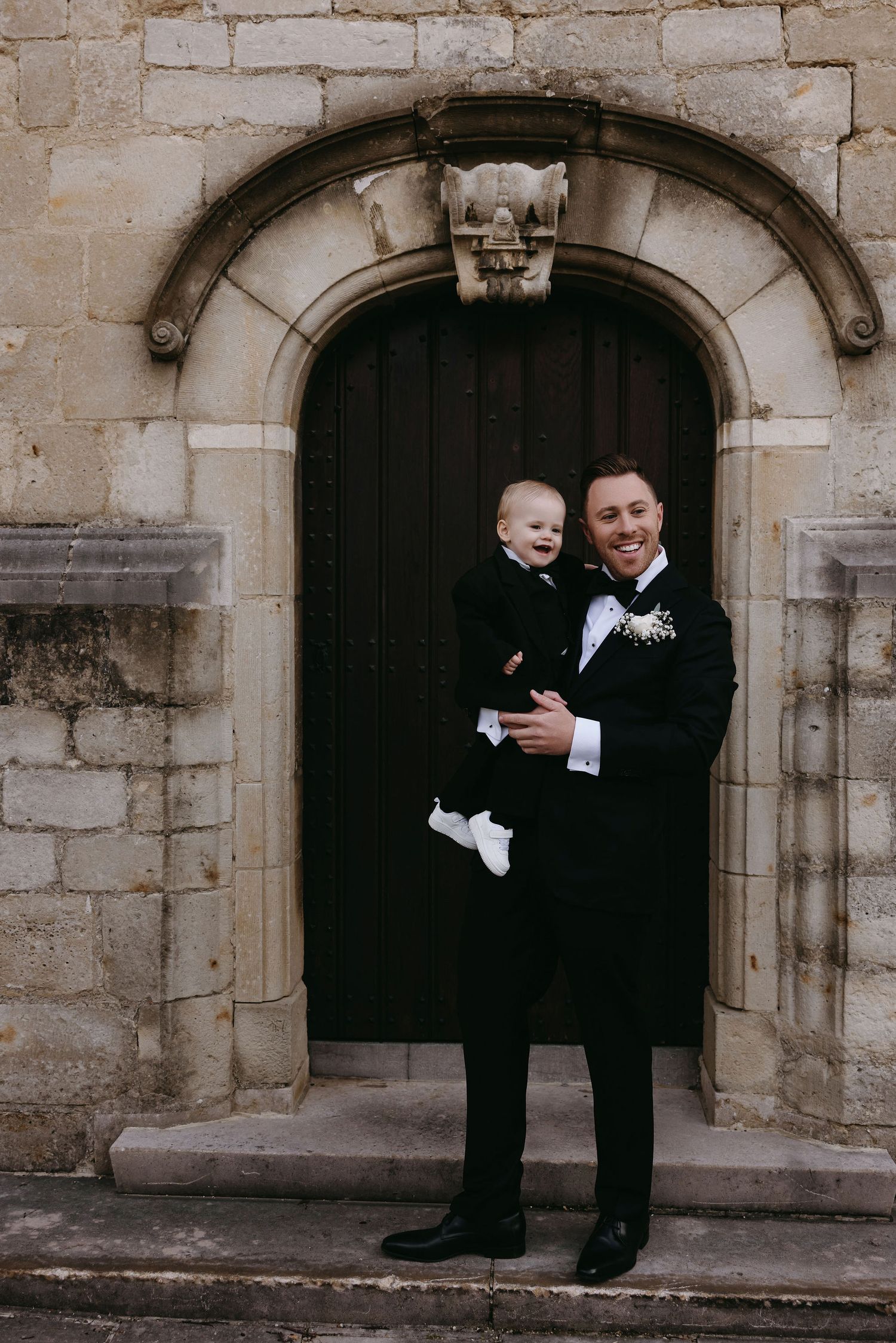A formal moment captured in front of a historic stone archway and door.