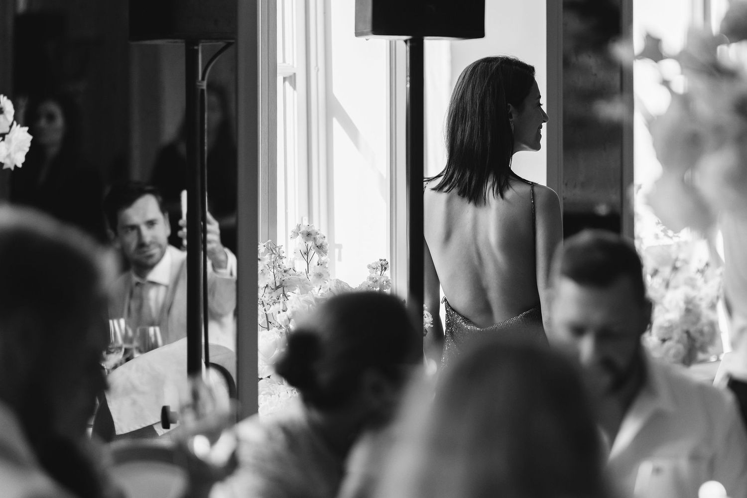 Candid black and white shots of wedding day preparations through window reflections.