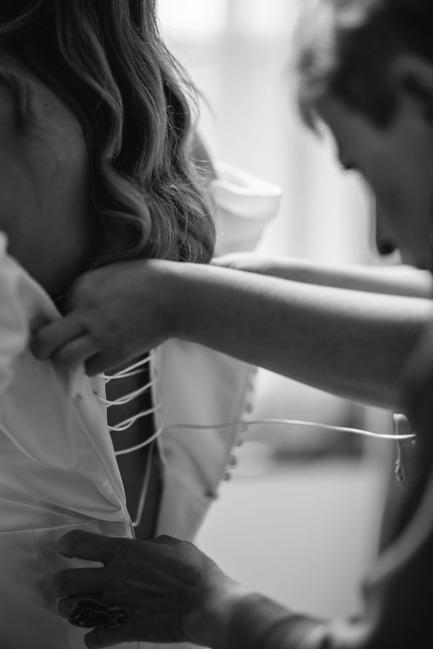 Close-up black and white shot of someone adjusting a dress.