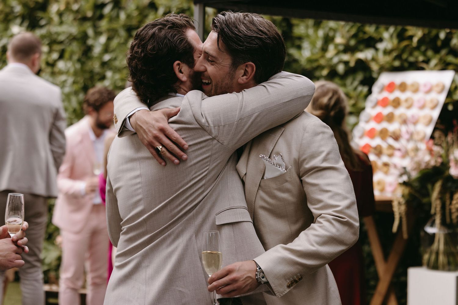 Emotional embraces shared during wedding celebrations in an outdoor garden setting.