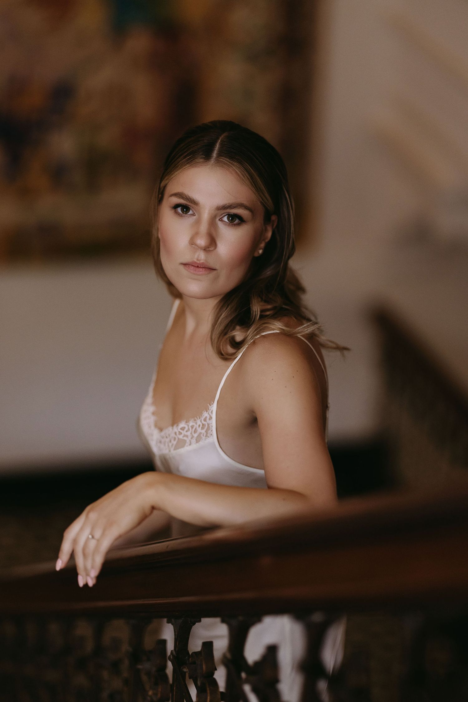 Portrait of a bride in a white lace top during wedding day preparations.