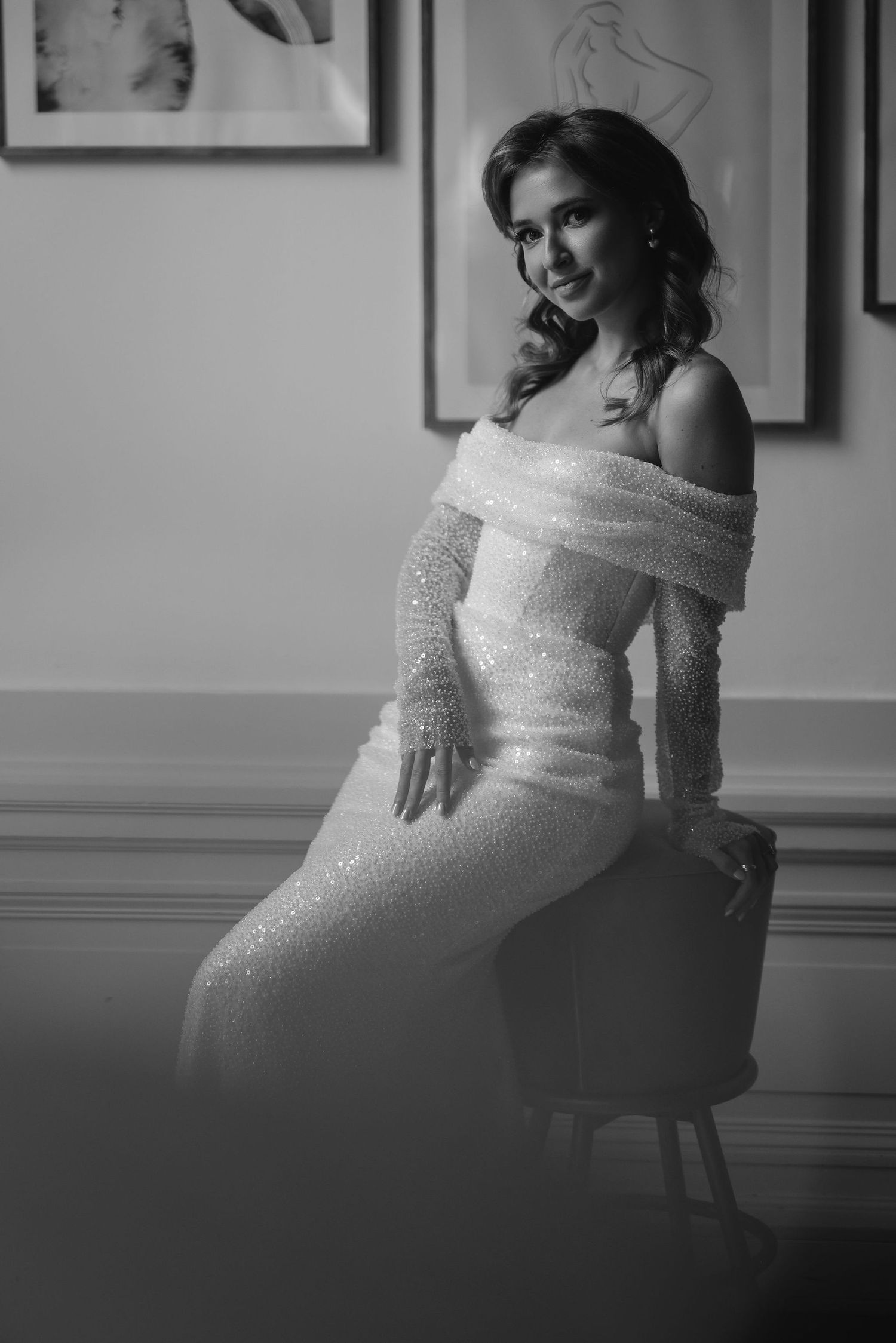 Bride in sparkling white dress seated for intimate portrait session.
