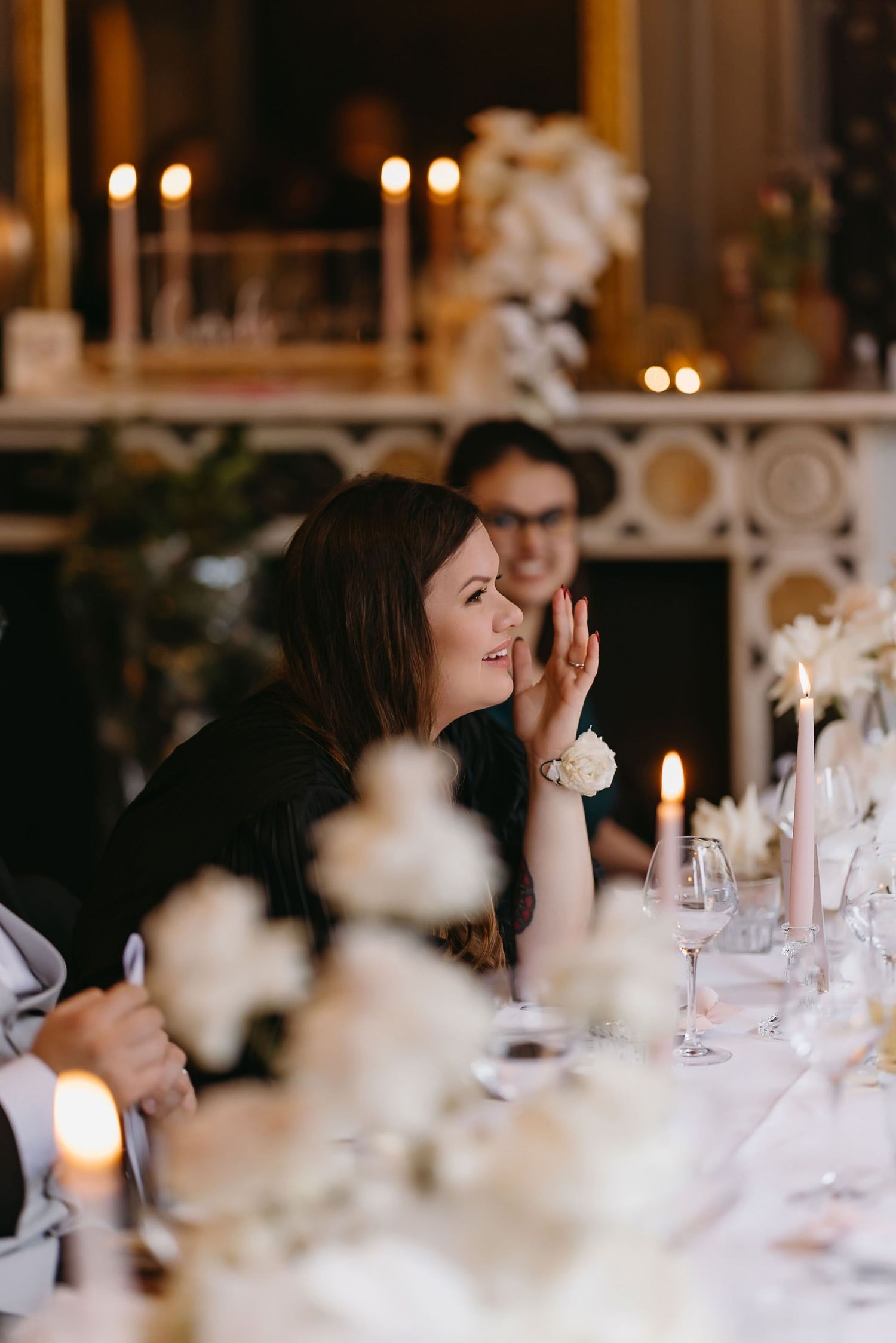 A candlelit dinner table setting with white floral centerpieces creates an elegant atmosphere.