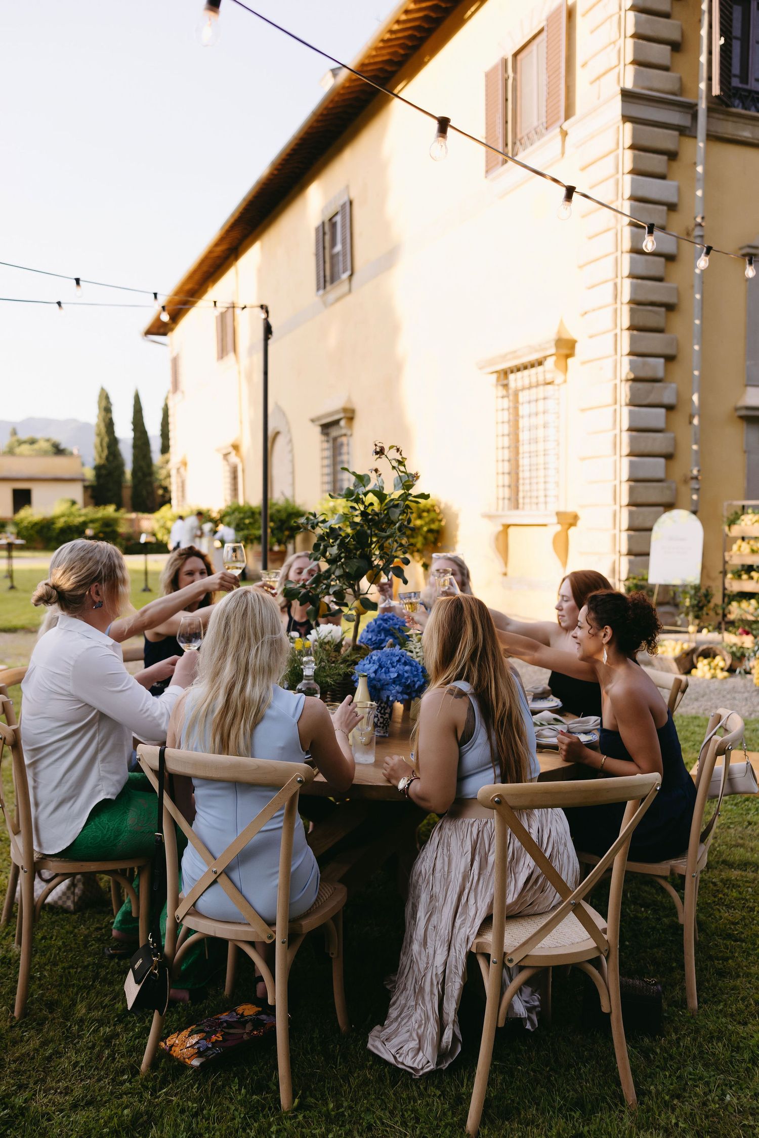Wedding guests enjoying an outdoor dinner reception at a rustic Italian villa.