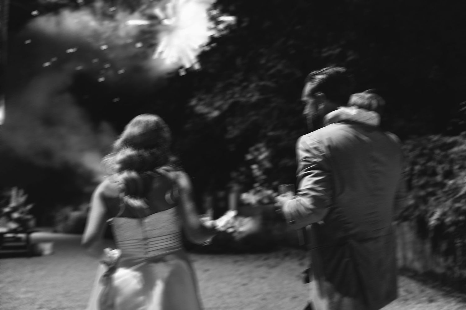Black and white photo of guests enjoying fireworks at an outdoor celebration.
